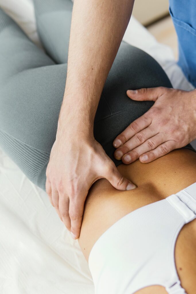 high angle male osteopathic therapist checking female patient s lower back spine